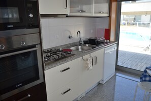 The kitchen is very well equipped, and has access to the patio and view of pool 