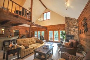 Living Room - Main Level. Spacious and high ceiling living area with comfy couches and chairs.