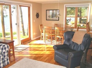 Living room and dining room with fireplace, hardwood floors and bay views.