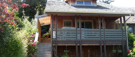 parking /storage, front door top of stairs. Deck / table four chairs and swing.