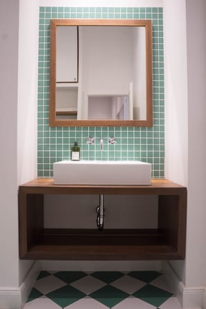 Emerald bathroom: Italian tiles and walnut furniture and details