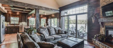 Living area with stone fireplace, huge fan, custom furniture and tall ceilings!
