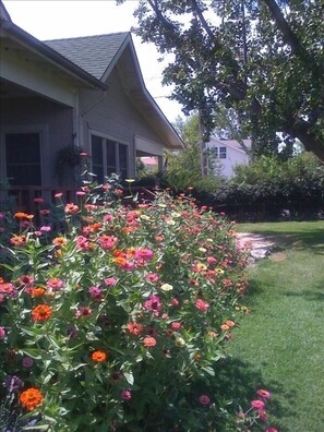 Landscaped yard with mature trees and flower gardens.