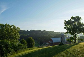 The Elegant Barn from the disc golf course. Cottage located beyond the barn.