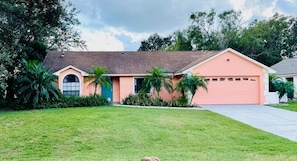 Freshly painted home in salmon color with teal door.