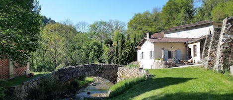 Vue sur la terrasse et la rivière qui traverse la propriété