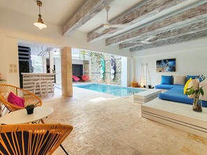 Living area, next to private pool, bar and half bathroom.