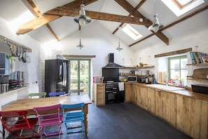 Stylish well equipped kitchen with exposed beams and handmade units