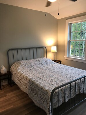 Bedroom 1 with queen size bed, closet, dresser and ceiling fan.