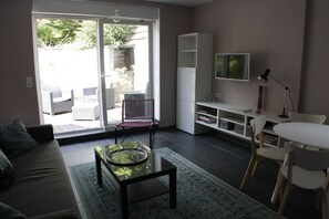 pièce de vie avec tv et canapé lit de 140 cm