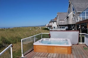The private hot tub is between the house and the ocean.
