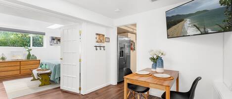 Wall-mounted TV with Netflix and Roku. French doors lead to the large bedroom.