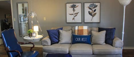 Comfy living space with kitchenette and large smart tv.