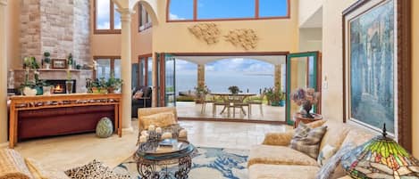 Our luxurious travertine livingroom spills out onto the lawn and bay