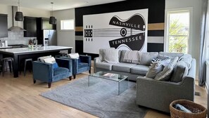 Unit 1 - Light Filled Living Room with amazing artwork, over-sized custom made sectional sofa, and plush arm chairs. Enjoy a movie on 65" SmartTV