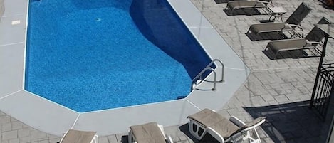 View from sliding glass doors of kitchen-portion of backyard pool area.