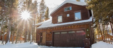 The house is set back on a quiet cul-de-sac surrounded by pine trees