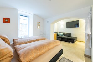 Ihr Wohn- und Schlafbereich mit Flat-TV, Couch und Boxspringbett