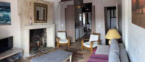 Le salon et sa cheminée en pierre de tuffeau.