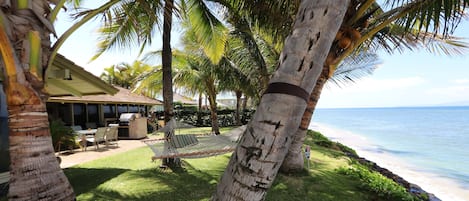 Our front grass, with hammock, lounge chairs, lanai and miles of ocean views!
