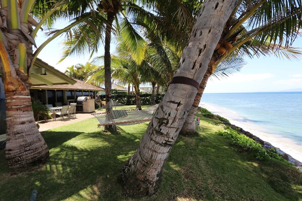 Our front grass, with hammock, lounge chairs, lanai and miles of ocean views!