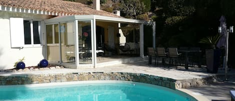 Vue de la Villa avec sa véranda, ses terrasses, sa piscine et son jardin typique