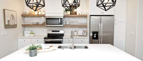 Kitchen island with custom light fixtures and open shelving.