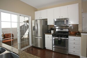 Updated with stainless appliances, kitchen opens to side patio with BBQ grill.