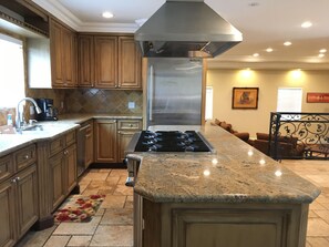 Beautiful open kitchen with granite counters and travertine floors