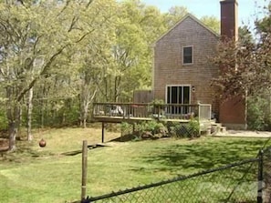 Side view of house- large yard is fenced