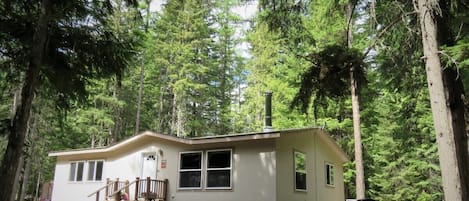 Front of house nestled in the woods.