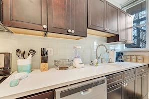 Glass tile surrounds this custom kitchen with a pull down faucet.