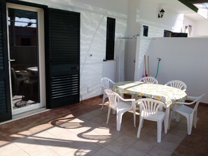 Veranda con tavolo e sedie da giardino e doccia esterna