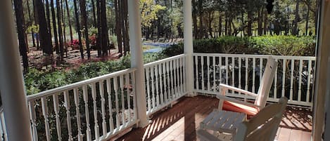 Front porch with rocking chairs, swing, and privacy within the pine trees