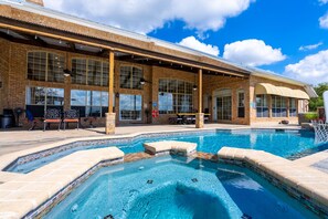 Outdoor patio and pool area with ping pong table, hot tub, and grilling area.