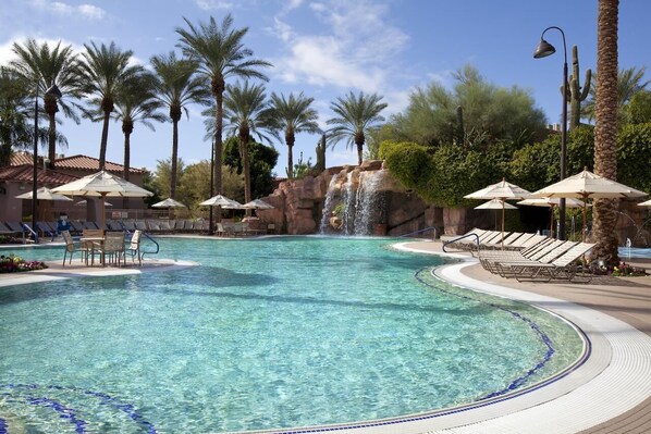 Pool area with waterfall and large hot tub 