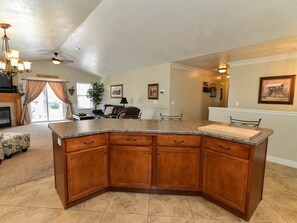 KITCHEN WITH LARGE BAR WITH 4 BAR STOOLS AND OPEN TO ADJOINING FAMILY ROOM