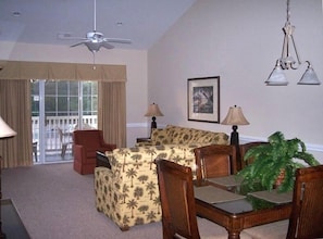 Living room with cathedral ceilings, balcony & dining area