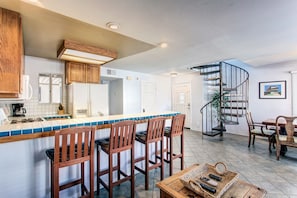 Open floor plan with kitchen, breakfast bar, dining and living space
