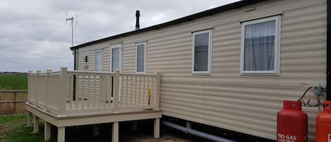 Decking at entrance door, has patio set to enjoy outdoors.