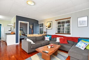 Open-plan lounge and dining area with flat-screen TV and DVD player, designed for relaxed family movie nights or quiet downtime.