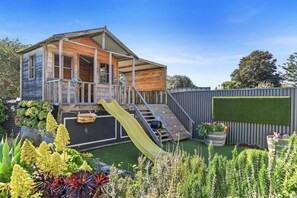 A grassy garden and a private terrace give you room to spread out, relax, and enjoy the coastal air. Outdoor shower for sandy beach returns
