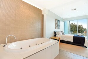 Luxurious master suite featuring floor-to-ceiling windows, balcony access, a double spa bath, and separate w/c for ultimate relaxation.