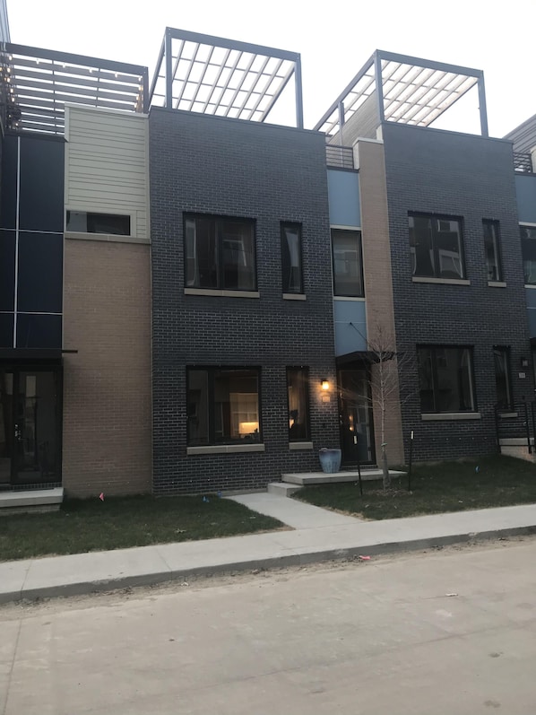 Front view of property with rooftop garden above