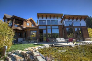 rear of the house with mountains reflecting in the floor to ceiling windows