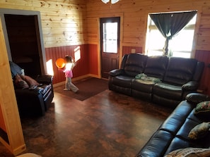 Downstairs area with tile floors, leather furniture.