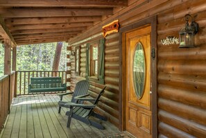 Front porch with swing and three Adirondack chairs