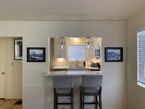 New kitchen with breakfast bar, stainless steel appliances, gas stove.