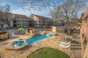 two hot tubs, tables and chairs, and charcoal grill right below you