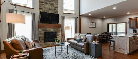 Living room showcase floor to ceiling stone fireplace leather sofas #Joyfullodge